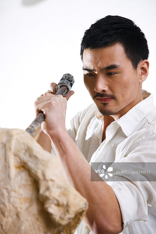 一个男雕塑家在工作室里创作图片素材