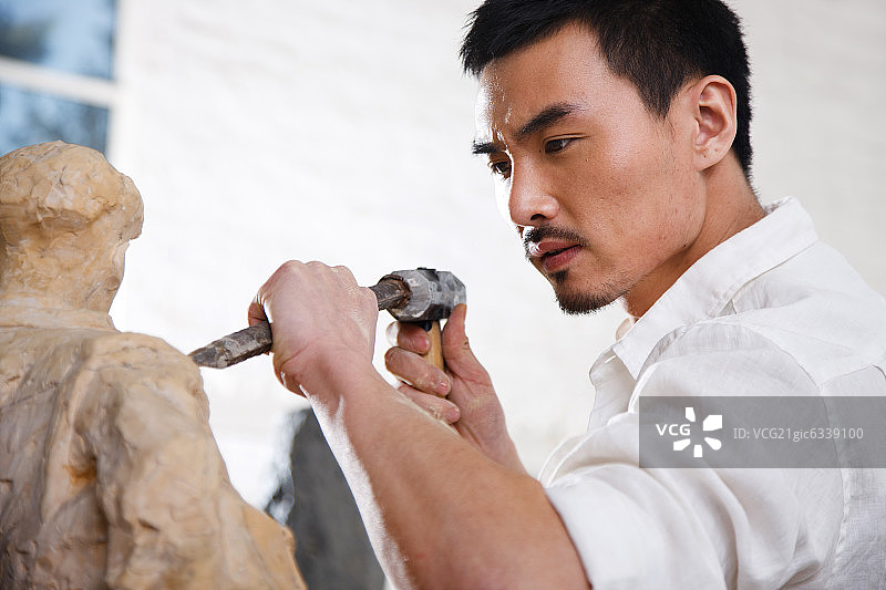 一个男雕塑家在工作室里创作图片素材