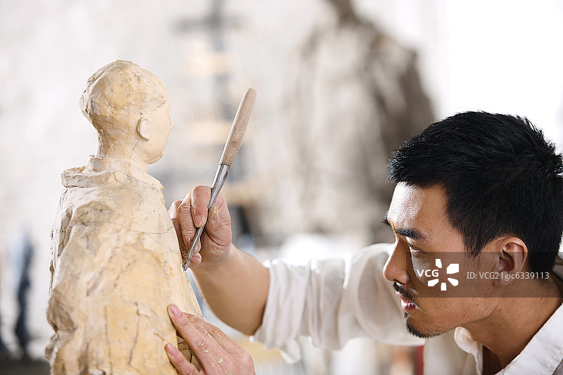 一个男雕塑家在工作室里创作图片素材