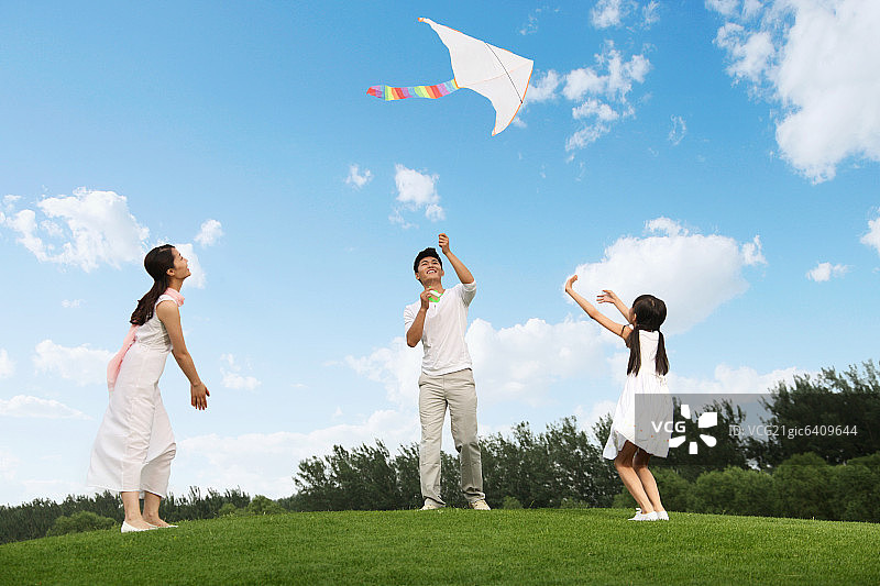 东方三口之家户外郊游放风筝图片素材