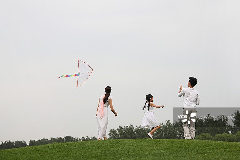 东方三口之家户外郊游放风筝图片素材