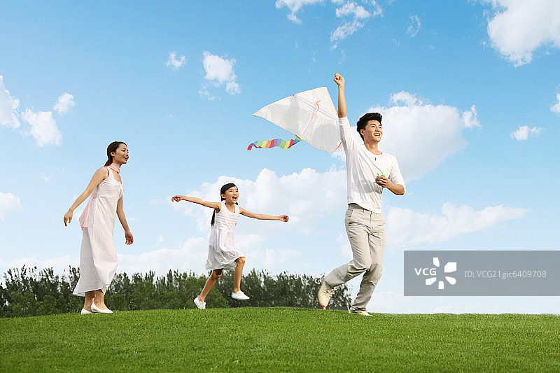 东方三口之家户外郊游放风筝图片素材