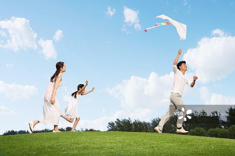 东方三口之家户外郊游放风筝图片素材