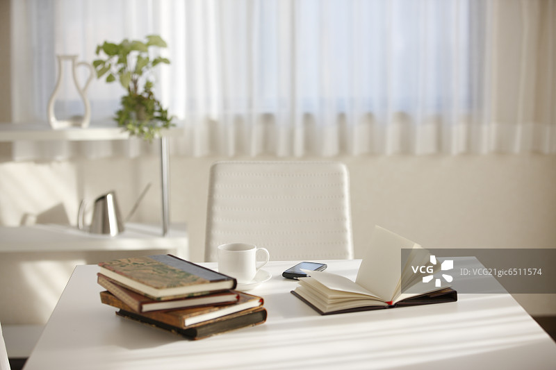 桌子上的书本、茶杯和手机图片素材