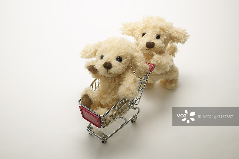 玩具狗在购物车中推着其他东西，白色背景图片素材