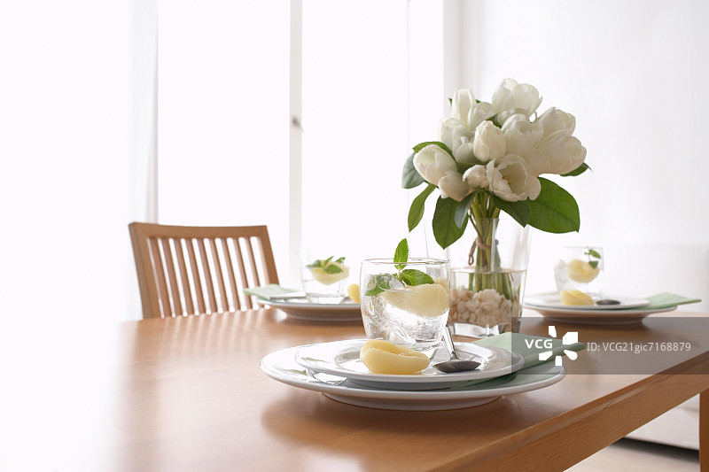 摆放着盘子和玻璃杯的餐桌图片素材