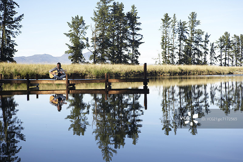 青少年在南非开普敦湖边弹奏吉他图片素材