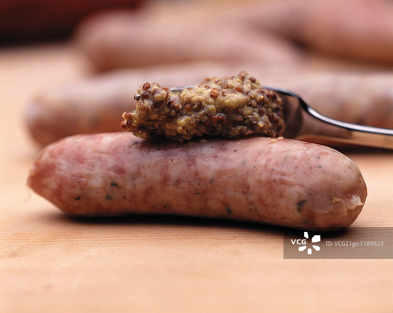 维也纳香肠上涂抹芥末图片素材