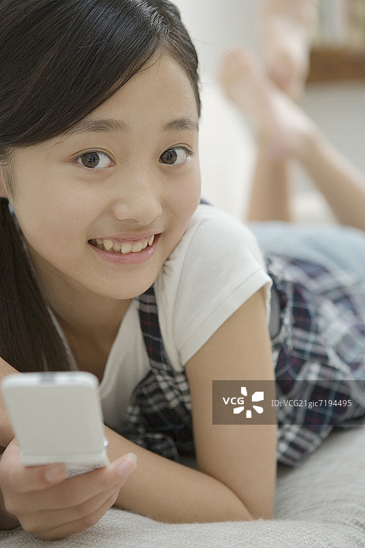 女孩沙发上微笑玩手机肖像图片素材