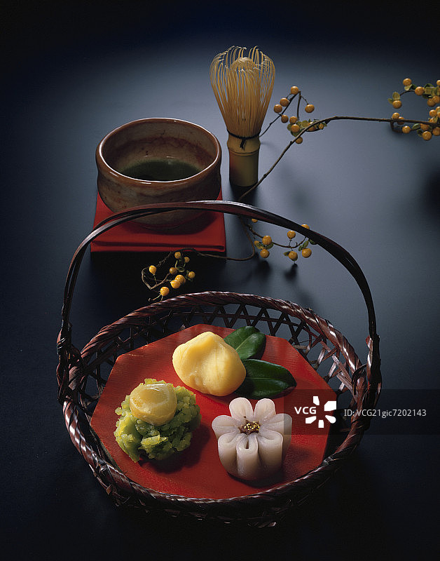 绿茶旁竹篮里的日式和果子图片素材