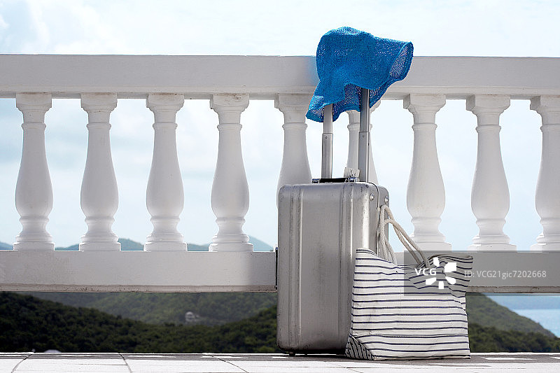 阳台上的遮阳帽和行李箱图片素材