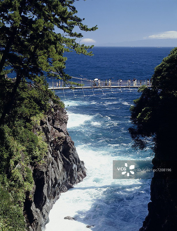 人们走在日本静冈县城崎海岸的悬索桥上图片素材