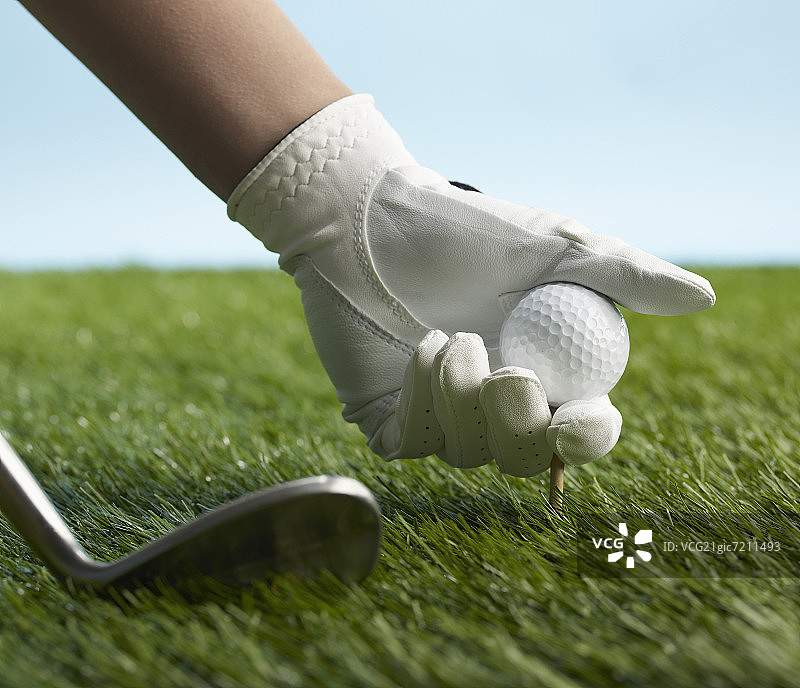 高尔夫球手在球座上放置高尔夫球图片素材
