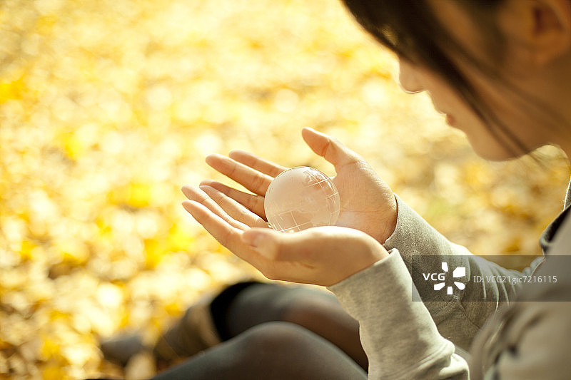 年轻女人拿着玻璃地球仪图片素材