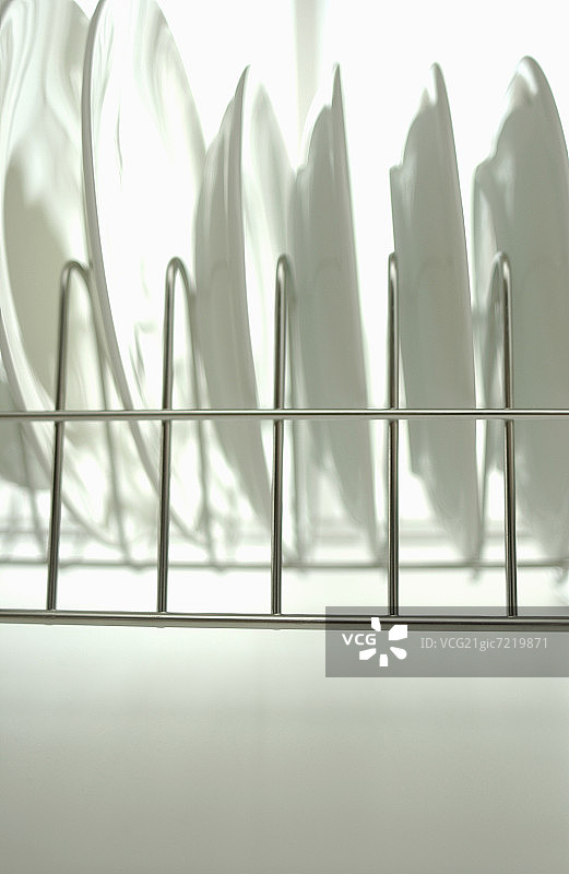 白色背景下碗碟架上的干净盘子图片素材