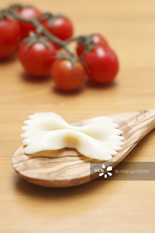 木勺上的蝴蝶面和番茄图片素材