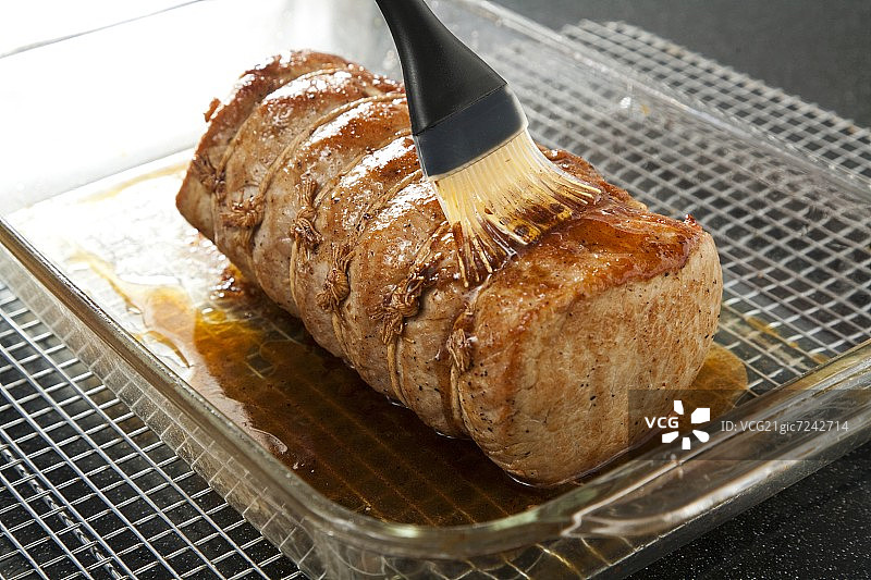 用刷子给猪里脊上釉图片素材