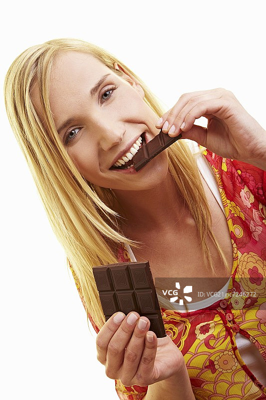 年轻女人咬了一块黑巧克力图片素材