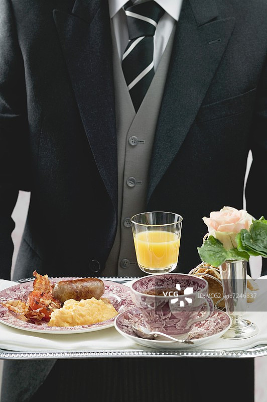 管家在托盘上提供英式早餐图片素材