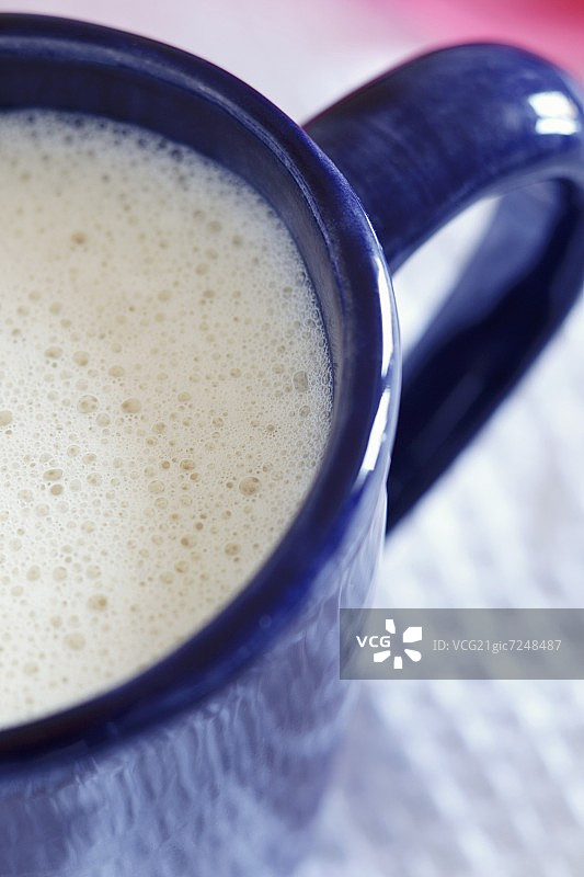蓝色马克杯中的香草豆奶图片素材