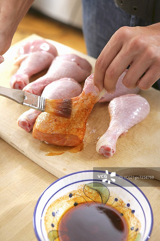 给鸡腿刷腌料图片素材