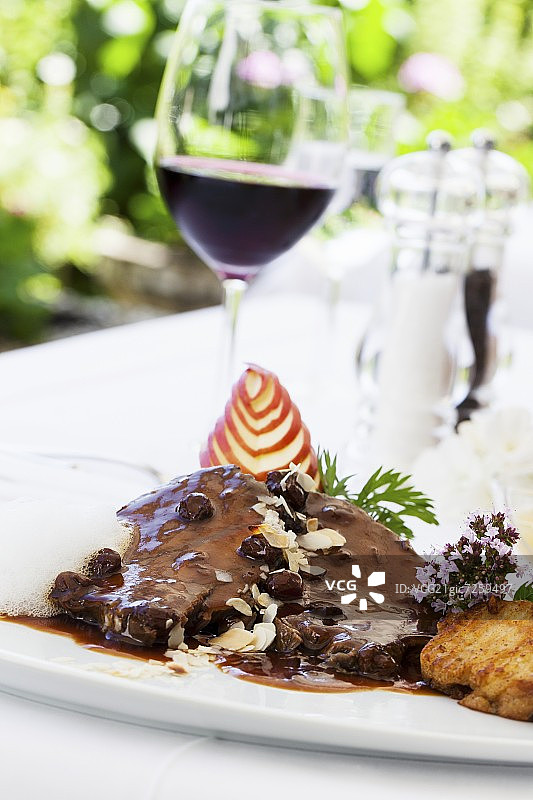 莱茵酸菜炖牛肉配葡萄干和餐巾纸饺子及一杯红酒图片素材