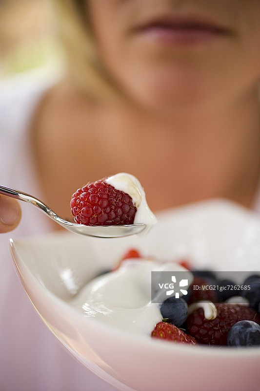 女人吃含酸奶的混合浆果麦片图片素材