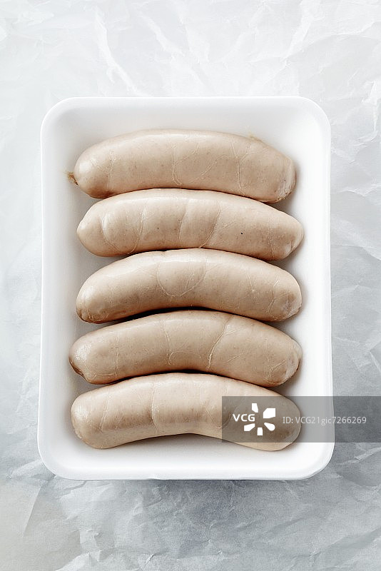 泡沫塑料托盘上的生白色香肠图片素材