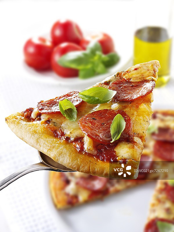 餐盘上的意大利香肠披萨切片图片素材