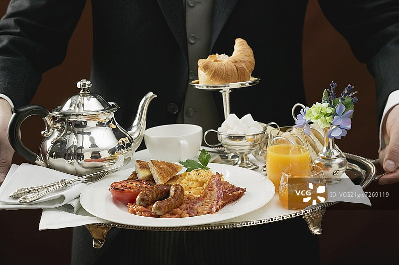 管家在托盘上提供英式早餐图片素材