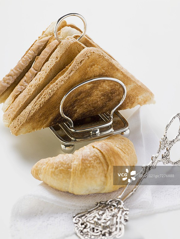 吐司架中的吐司、羊角面包和糕点钳图片素材