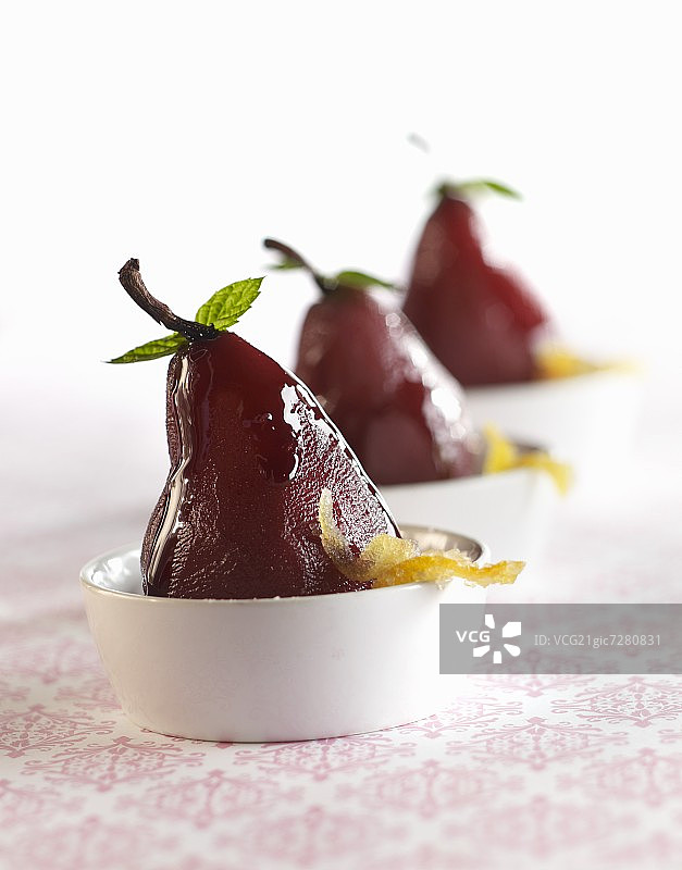 白色碗中带有糖果橙皮的煮梨图片素材