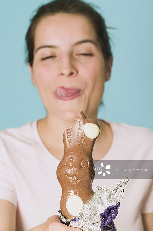 手拿咬了一口的巧克力复活节兔子图片素材