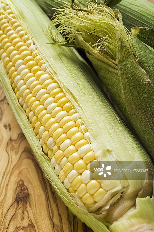 木板上带壳的玉米棒图片素材