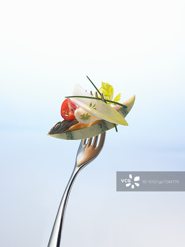 叉子上的甜瓜、芦笋和沙拉图片素材