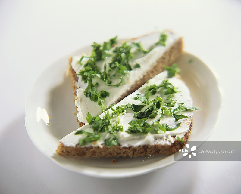 全麦面包上的软奶酪和欧芹图片素材