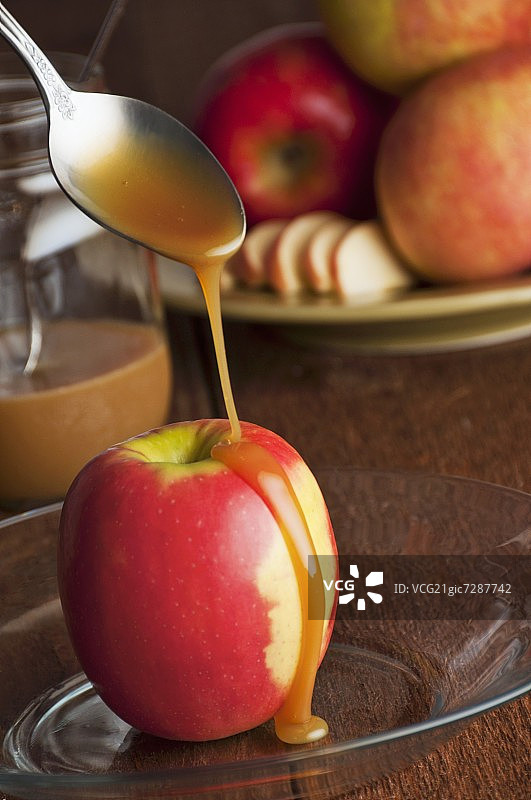 焦糖酱淋在有机粉红佳人苹果上图片素材