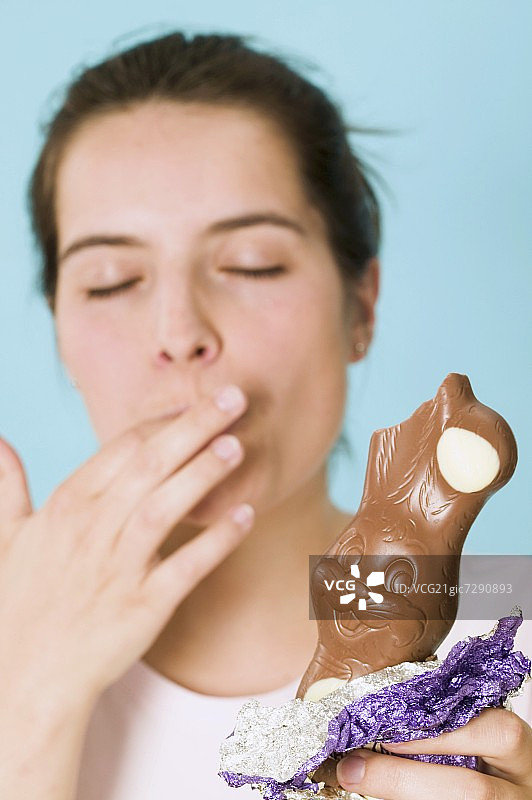 手拿咬了一口的巧克力复活节兔子图片素材