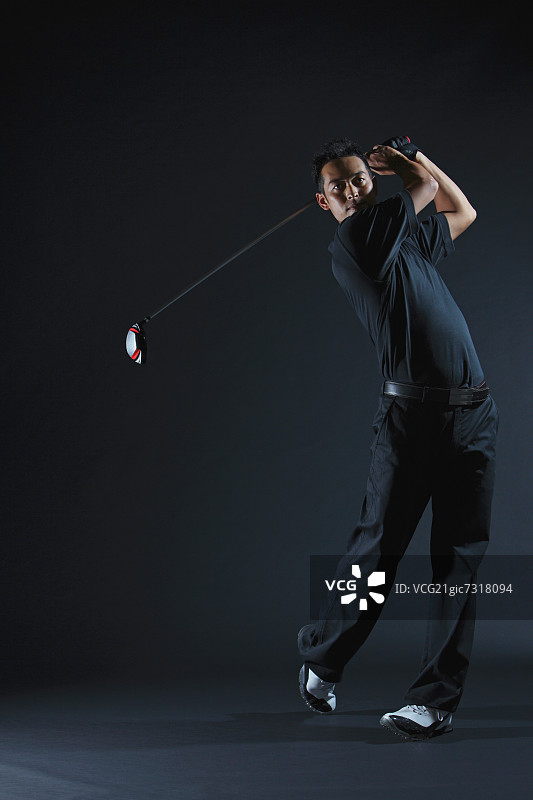 高尔夫球手击球后挥动球杆图片素材