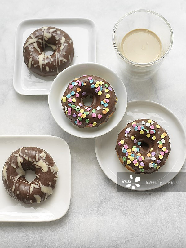 淋有白色巧克力和糖屑的巧克力甜甜圈图片素材