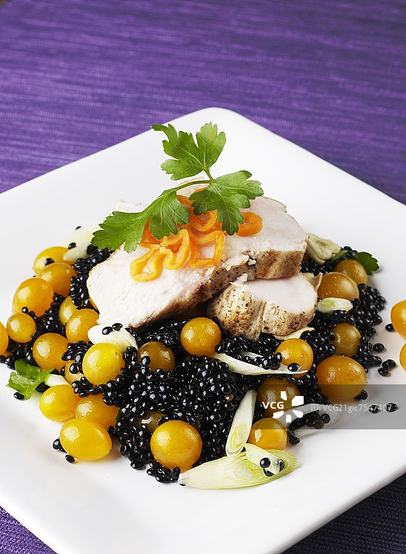 鸡胸肉配鲟鱼子酱、黄色樱桃番茄和韭葱图片素材