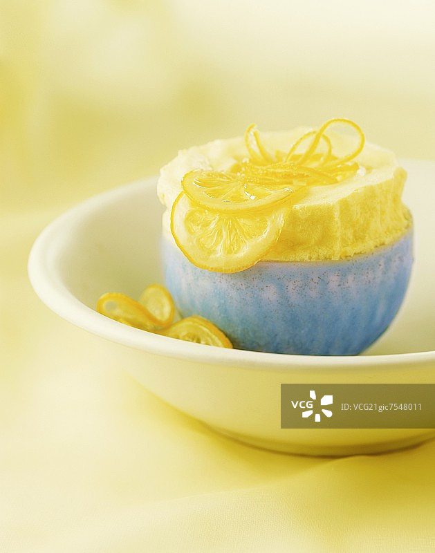 蓝色碗里的柠檬舒芙蕾与蜜饯柠檬片和柠檬皮图片素材