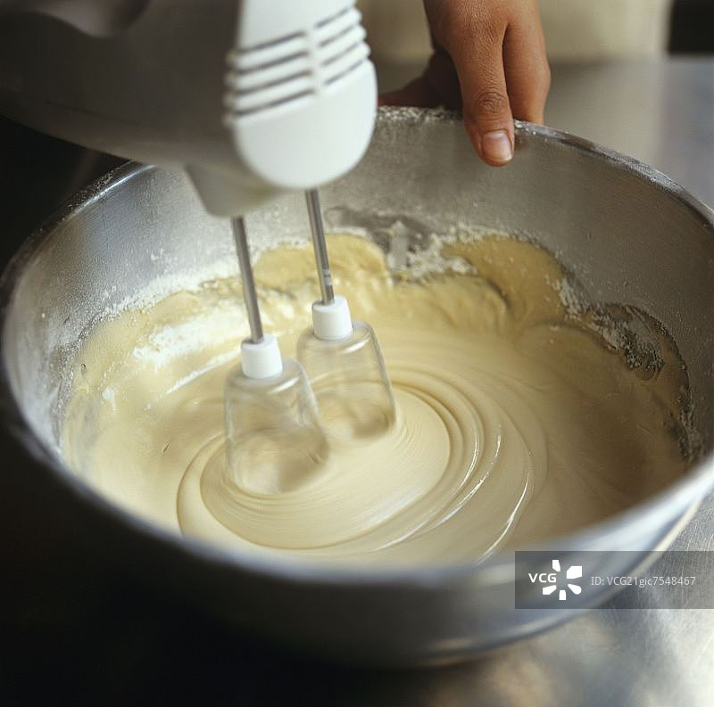 用电动搅拌器混合蛋糕糊图片素材