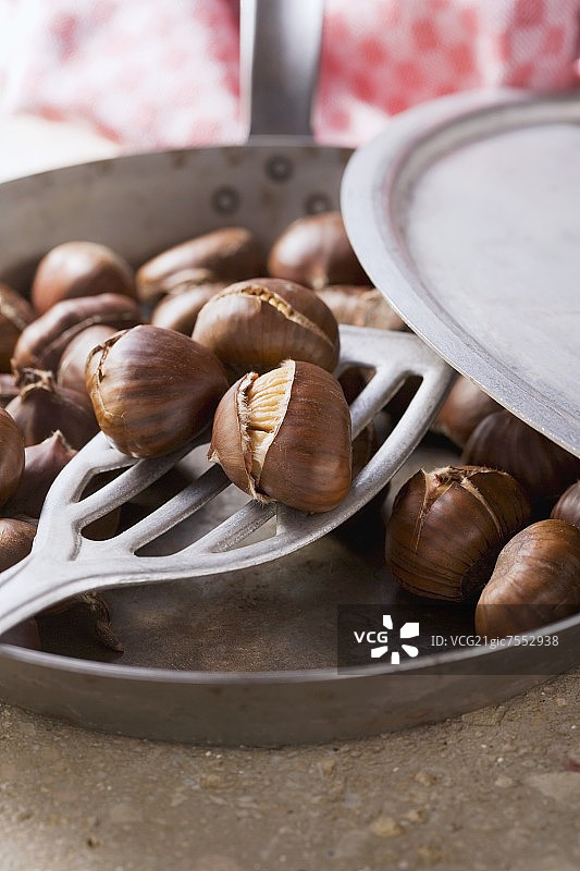 从锅里取出的烤栗子图片素材