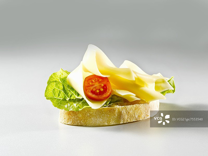 一片加有生菜、奶酪和番茄的白面包图片素材