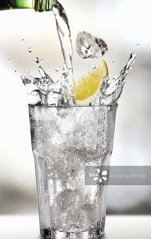 倒水入放有柠檬角玻璃杯图片素材