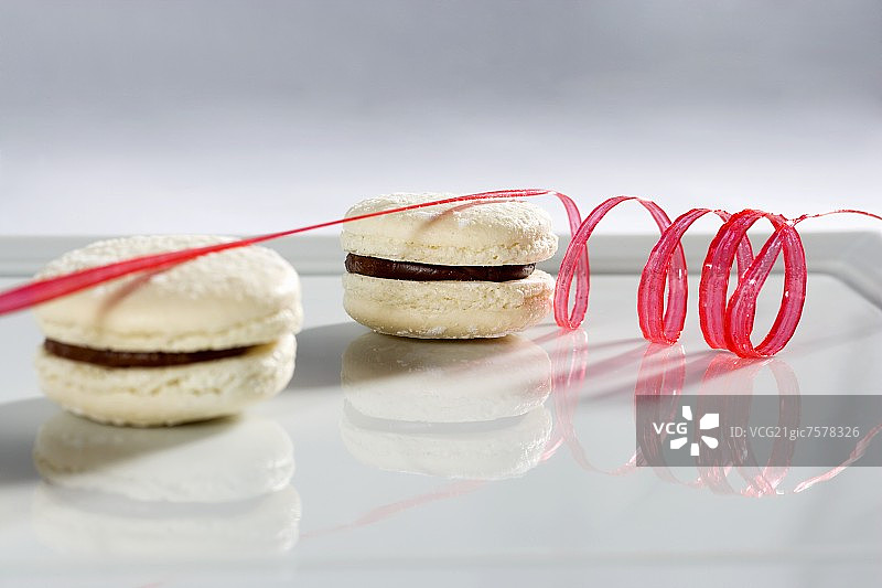 两个带有红色糖霜螺旋的白巧克力马卡龙图片素材