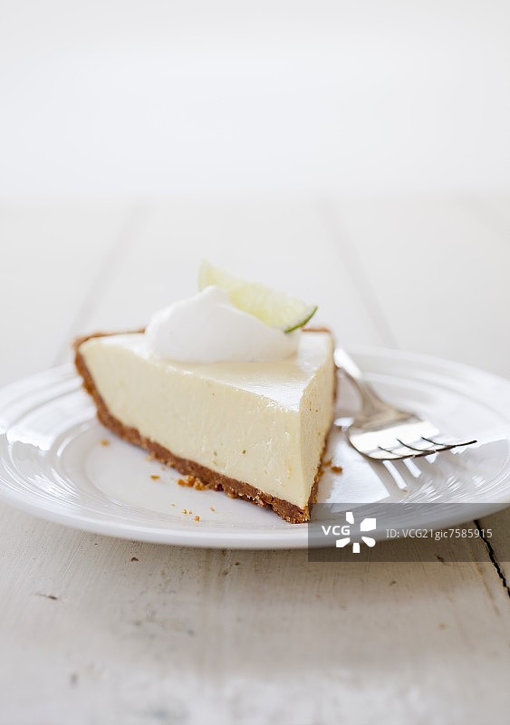 白色盘子上配叉子的酸橙派切片图片素材