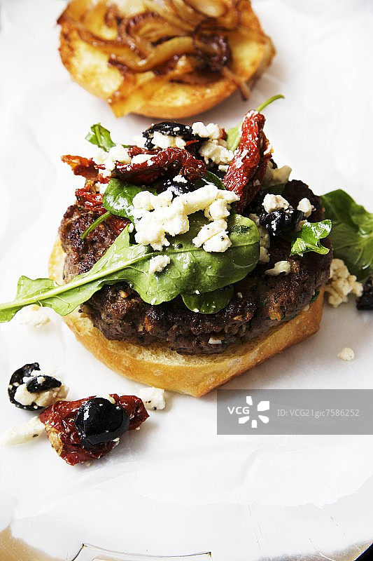 希腊羊肉汉堡配菲达奶酪、晒干的西红柿和橄榄图片素材