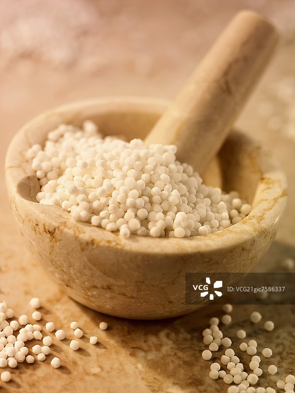 研钵中和旁边的白色西米珍珠图片素材